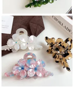 Détail de pinces à cheveux fleurs en acétate avec strass en vert, blanc et marbre