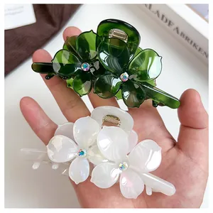 Détail macro de pinces à cheveux fleur en vert et blanc avec des strass étincelants