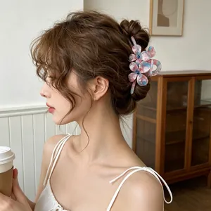 Pince à cheveux fleurie en acétate dégradé rose et bleu portée avec élégance