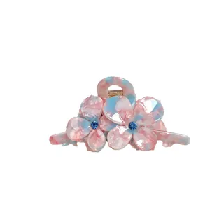 Pince à cheveux fleur avec texture marbrée rose et bleue et détails en strass