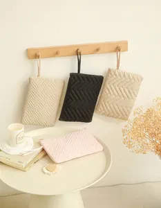 Detailed view of quilted makeup bags with top handles in four elegant neutral colors
