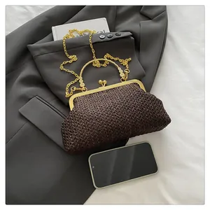 Détail d'un sac en paille tressée marron avec fermoir métallique doré et bandoulière