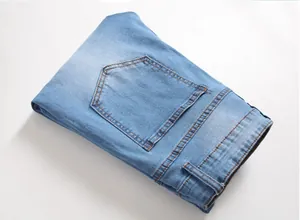 Detailed close-up of light blue denim fabric texture and stitching on rear pockets