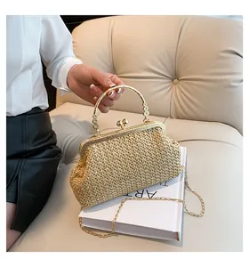 Detail of woven shell-shaped bag with gold vintage metal clasp and ring handle