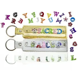 DIY sequin keychain detail showing leather straps with custom rhinestone letter sliders