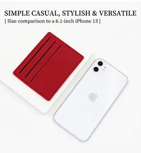 Slim red leather card holder with three slots shown next to a 6.1-inch phone for size scale