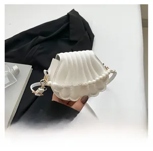 Détail du sac blanc en forme de coquille avec anse en perles et texture matelassée