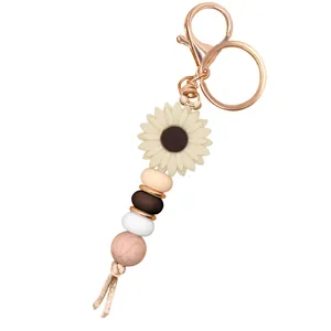Daisy sunflower keychain featuring beaded silicone and wood charms with rose gold hardware