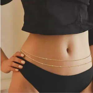 Close-up of double-layered gold waist chain with delicate beads on female model