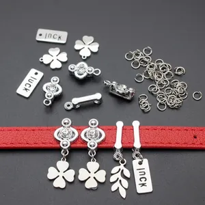 Close-up of DIY sequin keychain charms and luck clover pendants on a red leather strap