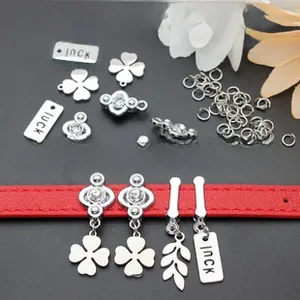 Close-up of DIY sequin keychain charms and luck clover pendants on a red leather strap