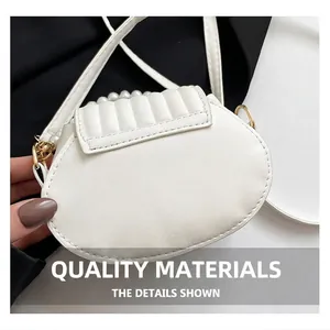 Nahaufnahme der weißen Handtasche mit Perlengriff, Steppnaht und goldener Metallschließe