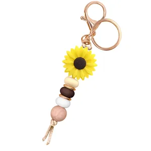Macro detail of sunflower keychain with silicone beads and rose gold lobster clasp
