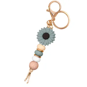 Detail of DIY daisy keychain with Morandi green sunflower charm and wooden beads