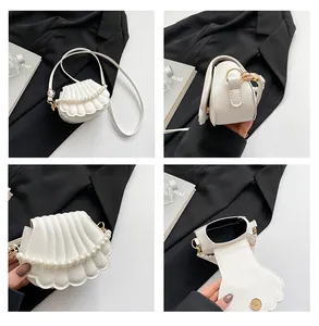 Détails du sac coquillage blanc avec perles, finitions dorées et fermoir magnétique