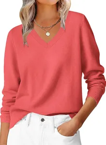 Detailed close-up of the ribbed V-neckline on a soft coral red knitted women's sweater