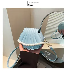 Vue détaillée du sac à main bleu clair en forme de coquille avec perles et doré