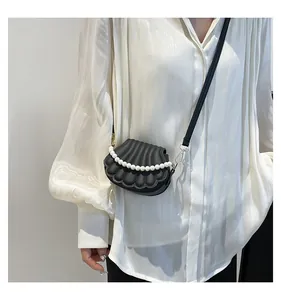 Détail du sac bandoulière en forme de coquillage avec chaîne perles et similicuir mat