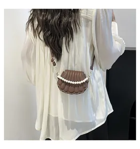 Détail du sac à bandoulière marron en forme de coquille avec chaîne en perles