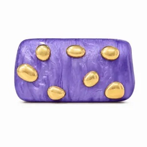 Detailed macro of a purple marble acrylic clutch bag with gold stone-shaped metal accents