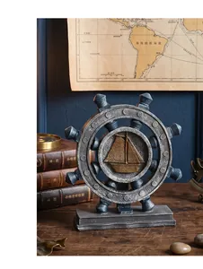 Close-up of vintage nautical ship wheel decor with golden sailboat relief on old map