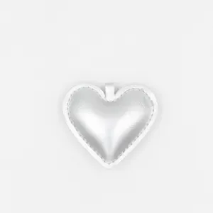 Détail d'un pendentif coeur en cuir PU argenté avec des coutures soignées