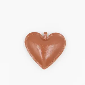 Détail d'un porte-clés en forme de cœur en cuir PU marron avec couture fine
