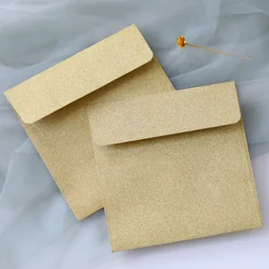 Detail of square rose gold glitter envelopes with a textured metallic finish and round flap