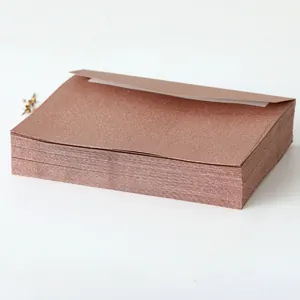 Close-up of premium rose gold glitter envelopes with elegant metallic shimmer texture