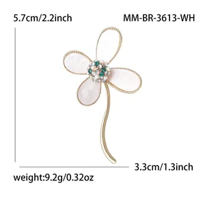 Elegant four-leaf clover brooch with white shell petals and gold trim accents