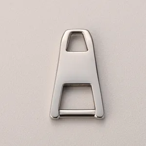 Macro shot of silver trapezoid stainless steel zipper puller on beige leather
