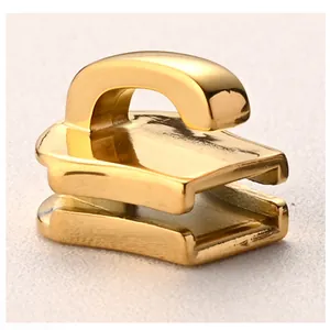Macro detail of polished gold stainless steel zipper slider for luggage and garments