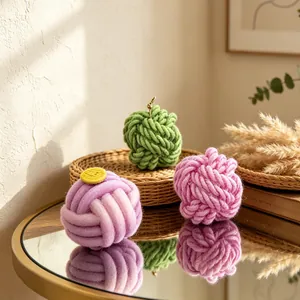 Three knot shaped yarn ball candles in green, purple and pink for home decor