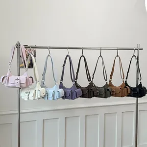 Close-up of stylish faux leather underarm bags in eight colors hanging on a metal rack