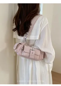 Detail of light pink multi-pocket shoulder bag with silver buckles and heart chain