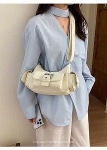 Detail of off-white retro crossbody bag featuring functional pockets and metal buckle