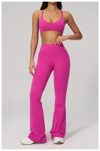 Full body view of a woman wearing pink flared yoga leggings and sports bra set