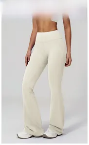 Detail of high waisted flare yoga pants in light apricot with sleek sports fabric texture