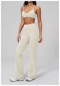 Detail shot of high-waist flared yoga pants and slim V-neck sports bra in off-white