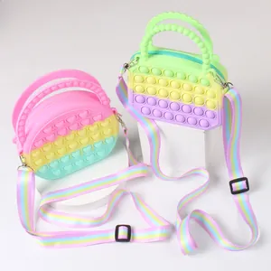 Detail of colorful pop-it fidget handbags with adjustable straps on geometric stands