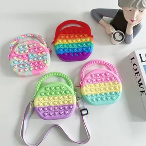 Detail of four colorful pop-it heart silicone bags with rainbow shoulder straps