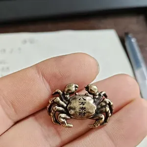 Macro shot of brass crab figurine showing Bafang Laicai engraving on the back