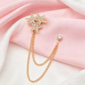 Elegant gold star chain brooch with sparkling rhinestones and tassels on silk fabric