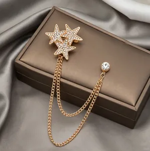 Elegant gold star brooch with rhinestones and double tassel chains on silk background