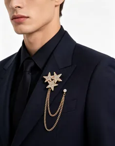 Macro detail of shining rhinestone star brooch with double gold hanging chains
