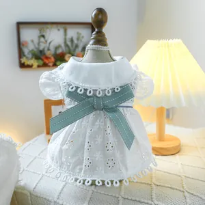 Close-up of white pet dress featuring delicate hollow embroidery and blue bow detail