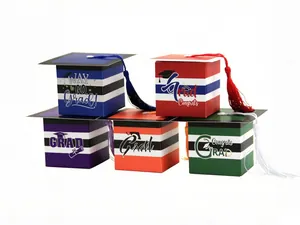 Close-up of colorful graduation cap candy boxes with stripes and tassels for party gifts