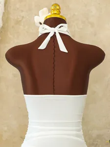 Detail of white halter neck swimsuit with ruffle trim and elegant tie-back bow