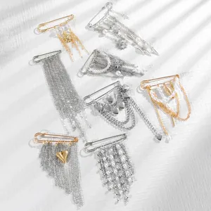 Detailed macro view of punk style chain brooches with metallic charms and pearls