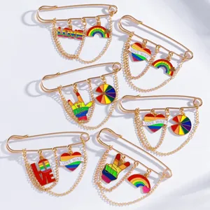 Detailed set of Pride enamel pins with gold chains and colorful rainbow heart pendants